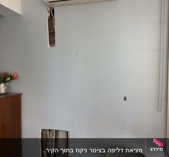 מזגן מותקן על קיר עם חור פתוח מתחתיו